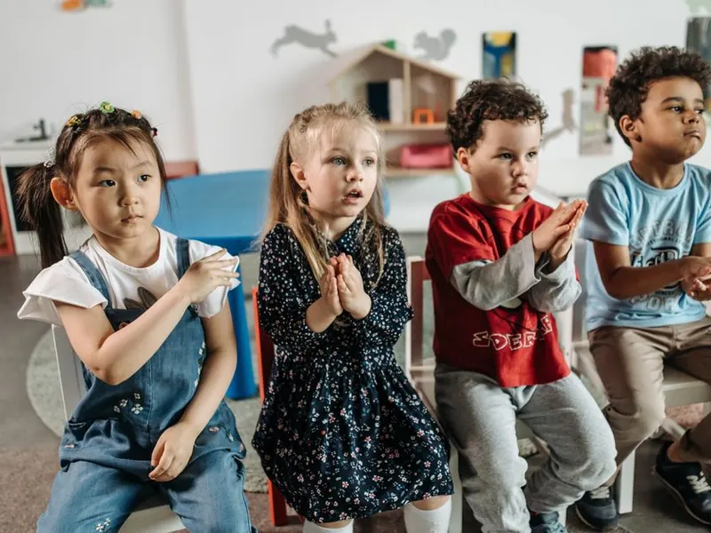 Preschoolers clapping along together.