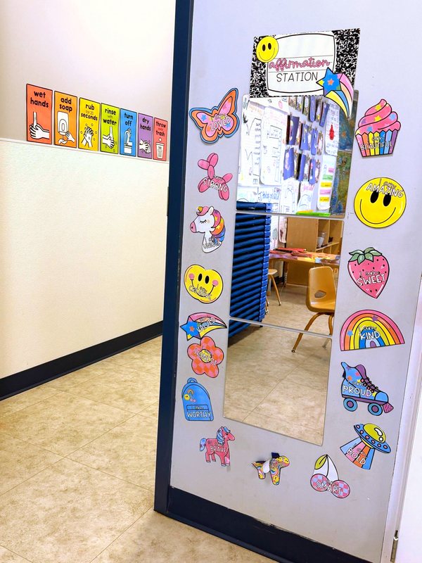 A Locust Grove Affirmation Station, a full-length mirror framed with positive-message stickers beside a hand-washing steps chart.